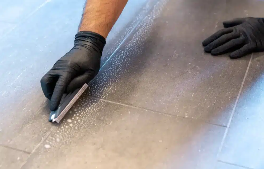 Using a soft brush to clean grout. 